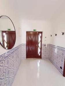 a hallway with two wooden doors and a mirror at Villa Madalena in Coucieiro +31 photos