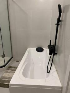 lavabo blanco en el baño con teléfono negro en Njikale Serviced Apartments - 6, en Lusaka