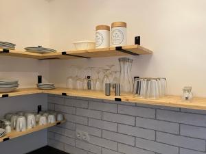 una cocina con estanterías de madera con vasos y platos en Vicinity KarLi, en Leipzig