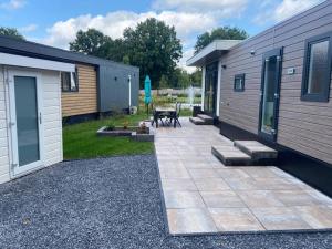 un patio con una mesa junto a un edificio en Kindvriendelijk luxe chalet in de bossen met privé sauna, en Harderwijk