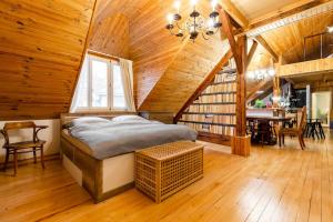 een slaapkamer met een bed in een houten kamer bij Rooftop 180m2 Loft with private SAUNA, in Bratislava