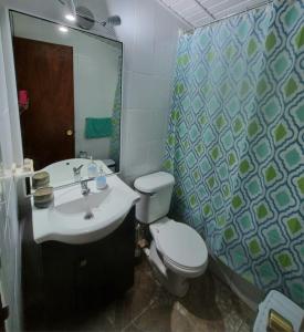 y baño con lavabo, aseo y espejo. en Casas Pamelas, en Algarrobo