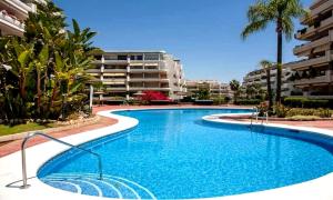 a swimming pool in a resort with a building at Apartamento en Marbella junto a campos de golf in Marbella