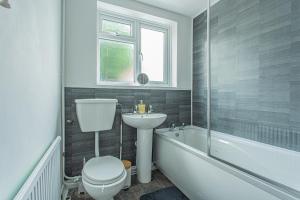 a bathroom with a toilet and a sink and a bath tub at Lorne Lodge Central Swindon in Swindon