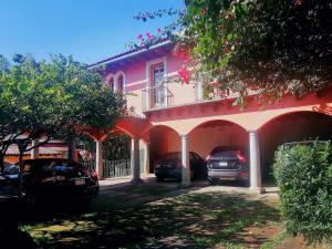 Quinta las Ánimas في خالابا: مبنى وردي فيه سيارات متوقفة أمامه
