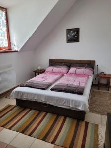 a bedroom with a bed with pink sheets on it at Tótvár lovas szálláshely in Kővágótőttős