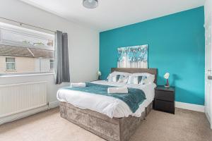 a bedroom with a large bed with a blue wall at Lorne Lodge Central Swindon in Swindon