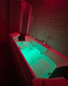 a jacuzzi tub in a room with red lighting at RooMYitalia - Guest House Il Faraone in Fiumicino
