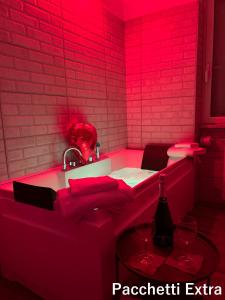 a pink bathroom with a sink and a red light at RooMYitalia - Guest House Il Faraone in Fiumicino