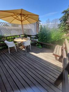 a wooden deck with a table and an umbrella at Casas Pamelas in Algarrobo