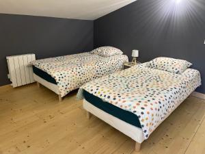 1 Schlafzimmer mit 2 Betten mit Polka-Punkten-Bettwäsche in der Unterkunft Gîte La Rive Gauche in Saint-Même-les-Carrières