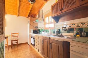 a large kitchen with wooden cabinets and a sink at Casa Canillas - for solo travelers or small groups of 4 to 6 people in Canillas de Aceituno