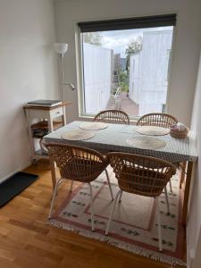 a dining room table with chairs and a window at Mellbystrand Björkvägen Apartment in Mellbystrand