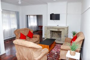 a living room with two chairs and a fireplace at 57 on Lorne Guesthouse in Estcourt