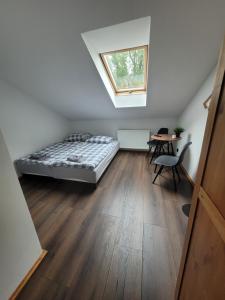 a bedroom with a bed and a table in it at Gościniec Błogocice in Cieszyn