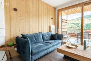 a living room with a blue couch and a table at Appartement Maïnou à La Bresse in La Bresse