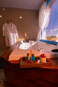 a bathroom with a bath tub with a robe at Chalés Corucacas in Cambará