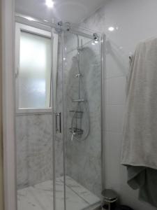 une douche avec une porte vitrée dans une salle de bain dans l'établissement Maison spacieuse & confortable pour 4 - Grand Mont, à Saint-Gildas-de-Rhuys