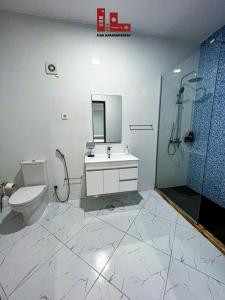 a bathroom with a toilet and a sink and a shower at Figo Apartamento Sol & Brisa Cidadela T2 in Praia
