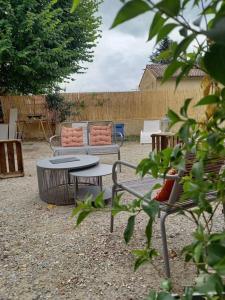 蒙布舍敘爾雅布龍的住宿－Le studio d'Alexandre - Terrasse et Parking -，庭院配有两把椅子、一张桌子和一张长凳