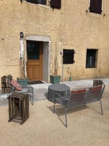 duas cadeiras e uma mesa em frente a um edifício em Le studio d'Alexandre - Terrasse et Parking - em Montboucher-sur-Jabron
