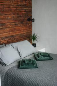 a bed with two green towels on top of it at "Quiet Center" apartment, close to train station in Tukums