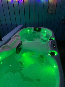 a green bath tub with green lights on it at The Croft Accommodation in Gamrie