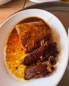 un plato blanco con tres trozos de carne en una salsa en Glamping Miraflores, en Vicuña