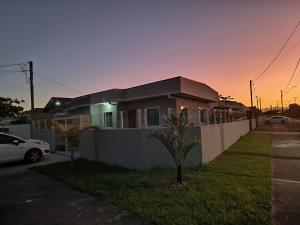 une maison dans une rue avec une clôture dans l'établissement Casa alguns passos do mar com piscina e SPA Aquecido, à Guaratuba