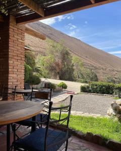 a patio with tables and chairs and a view of a mountain at Glamping Miraflores in Vicuña