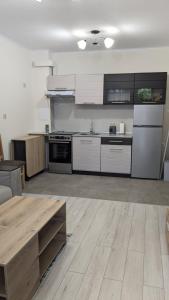 a kitchen with white cabinets and a wooden table at Сарафово Център in Burgas City
