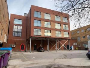 a large brick building in a parking lot at The Madison Apartment by TTLG Stays in Hemel Hempstead