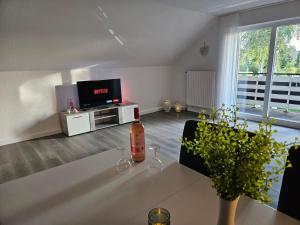ein Wohnzimmer mit einer Flasche Wein auf dem Tisch in der Unterkunft Ferienwohnung Birkenstraße in Ihlow