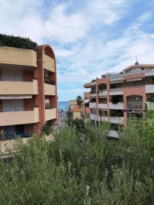 two tall apartment buildings with vegetation in front of them at Villa Véronique in Roquebrune-Cap-Martin