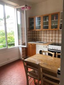 a kitchen with a wooden table and a table and chairs at Villa Véronique in Roquebrune-Cap-Martin +11 photos