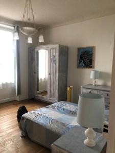 a bedroom with a bed and a table with a lamp at Villa Véronique in Roquebrune-Cap-Martin
