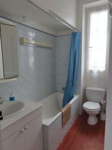 a bathroom with a toilet and a sink and a tub at Villa Véronique in Roquebrune-Cap-Martin