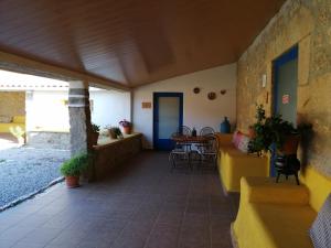 um alpendre de uma casa com uma mesa e cadeiras em Monte da Fonte Santa de São Luís em Castelo Branco