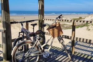 two bikes are parked on a pier at the beach at Apartamento uma quadra do mar, melhor localização in Capão da Canoa
