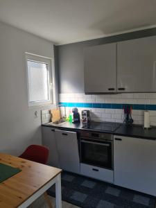 a kitchen with white appliances and a wooden table at Schöne 2 Zimmer Apartment City, Netflix &Prime in Krefeld