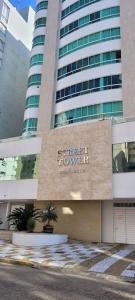 Un edificio con un cartel que dice Grand Hotel Tower. en Apartamento uma quadra do mar, melhor localização, en Capão da Canoa