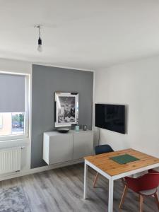 a living room with a table and a tv at Schöne 2 Zimmer Apartment City, Netflix &Prime in Krefeld