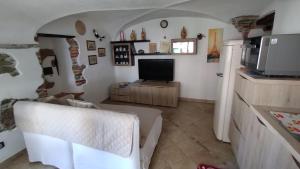 a living room with a couch and a tv and a kitchen at Dal Pescatore in Arenzano