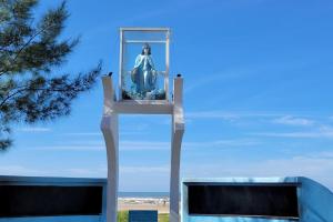 Una estatua de una mujer a caballo en una torre. en Apartamento uma quadra do mar, melhor localização, en Capão da Canoa