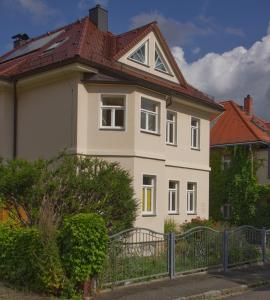 een wit huis met een hek ervoor bij Apartment Traumzeit mit Balkon in Vorstadtvilla in Dresden