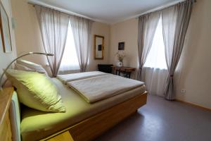 a bedroom with a bed with a lamp and two windows at Ferienhaus Tolazzi in Arnoldstein