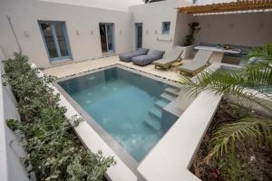 uma piscina no meio de uma casa em Tholaki luxury home em Kamari