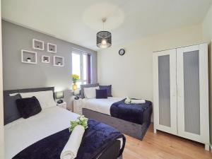 考文垂的住宿－Beauchamp Suite in Coventry City Centre for Contractors Professionals Tourists Relocators Students and Family，一间卧室设有两张床和窗户。