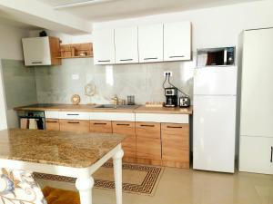 a kitchen with wooden cabinets and a white refrigerator at Enjoy BDF in Vatra Dornei