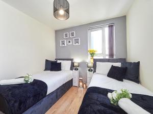 a bedroom with two beds and a window at Beauchamp Suite in Coventry City Centre for Contractors Professionals Tourists Relocators Students and Family in Coventry